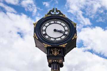 Fototapeta na wymiar Big clock in the city centre of Stourbridge on sunny day . Big clock on the blue sky in United Kingdom
