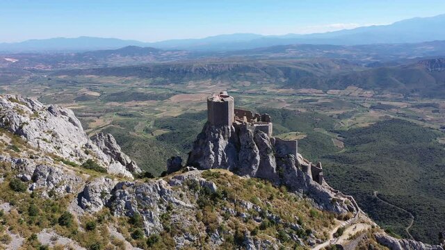 Aerial view of stone ruins of ancient fortified Chateau de Queribus on rocky hilltop on sunny summer day, Aude departement, France