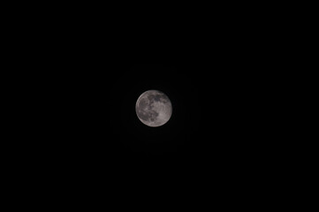 Waning moon on a dark sky. Moon with craters.