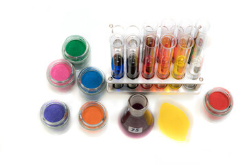 Pigments in jars, solutions in test tubes on a rack and a flask 