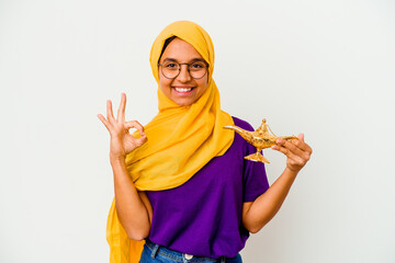 Young muslim woman holding a lamp isolated on white background cheerful and confident showing ok...