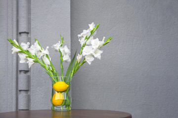 Concept summer flowers setting decoration fresh interior with concrete wall cafe design elements of organic restaurant. Fresh plants in organic cafe table flowers vase with lemons in vegan restaurant.
