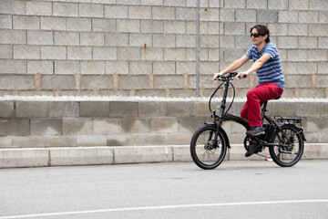 Man driving electric bike to work with dark sunglasses
