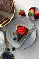 Slice of chocloate cheesecake with strawberries and blueberries, top view.