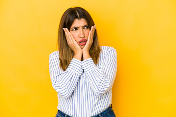 Young indian woman isolated on yellow background scared and afraid.