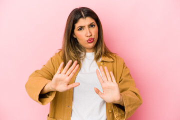 Young indian woman isolated on pink background rejecting someone showing a gesture of disgust.