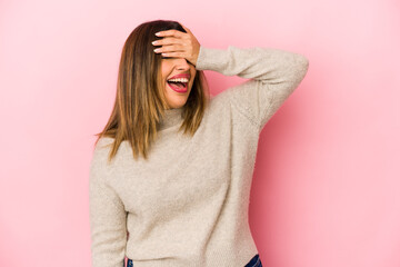 Young indian woman isolated on pink background laughs joyfully keeping hands on head. Happiness concept.