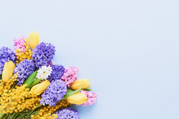 Spring flowers bouquet on a light blue background. Mothers day, Valentines Day, Birthday celebration concept.
