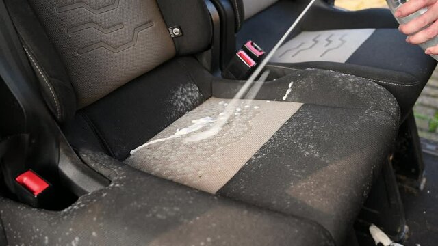 Cleaning solution is sprayed onto mold on a car seat that has been laid up for several months