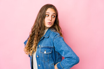 Young caucasian woman looks aside smiling, cheerful and pleasant.