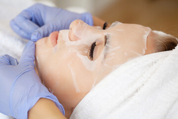 Spa, attractive funny women with fabric mask on face.