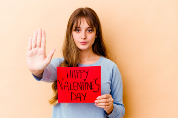 Fototapeta na wymiar Young caucasian woman holding a Happy Valentines day isolated standing with outstretched hand showing stop sign, preventing you.