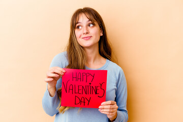 Fototapeta na wymiar Young caucasian woman holding a Happy Valentines day isolated dreaming of achieving goals and purposes