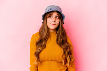 Young caucasian woman wearing fishermans hat isolated confused, feels doubtful and unsure.