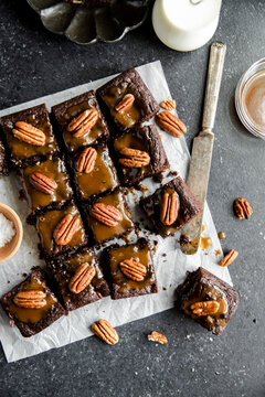 Turtle Brownies with salted caramel and pecan topping in a flatlay.