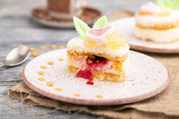 Decorated cake with milk and coconut cream with cup of coffee on a gray wooden background. Side view, selective focus.