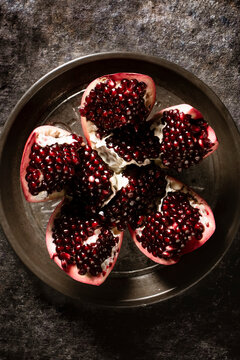 Pomegranate sliced open on a pie plate.