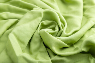 Fragment of green linen tissue. Side view, natural textile background.