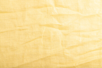 Obraz premium Fragment of smooth yellow linen tissue. Top view, natural textile background.