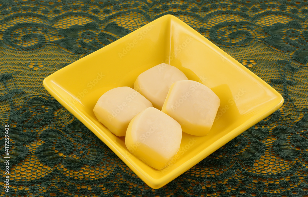 Canvas Prints White chocolate and lemon meringue candy pieces in yellow candy dish on green lace table runner on yellow table runner