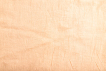 Fragment of smooth orange linen tissue. Top view, natural textile background.