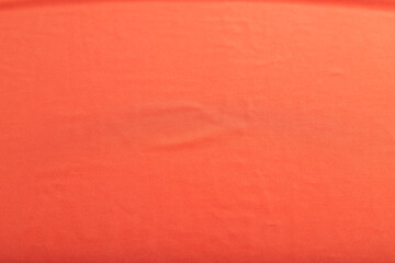 Fototapeta premium Fragment of smooth red silk tissue. Top view, natural textile background.