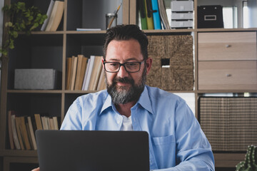 one young man working at home in the office with laptop and notebook talking in a video conference. One businessman calling communicating