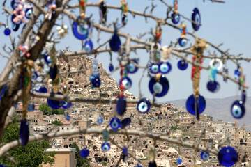 Evil eye in tree behind Uchisar Castle in Cappadocia, Nevsehir, Turkey. Cappadocia is part of the UNESCO World Heritage Site.