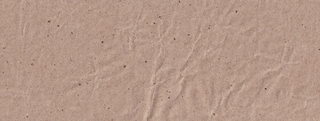 Fototapeta na wymiar Narrow horizontal photo of crumpled kraft. Light brown paper background with fine grains. Textured surface template for eco banner, poster