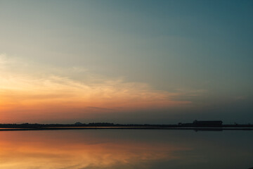 Fototapeta premium Colorful sunset landscape view of salt farm or salt pan in Thailand.