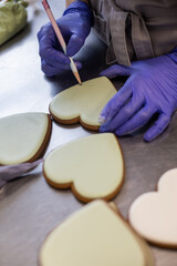 The pastry chef paints gingerbread with decorative sugar glaze.