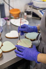 The pastry chef paints gingerbread with decorative sugar glaze.
