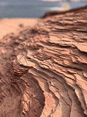 Closeup of desert rock by water in the sun with shadows