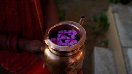 Copper Kalsh full of sacred water and aroma flowers. Sacred Kalash or Mug to worship God. Hindu religion concept.
