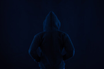 Faceless man wearing a dark black top for use with technology and cyber criminal concepts and ideas