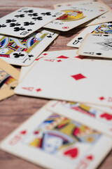 Deck of poker cards scattered on a wooden table. selective focus.