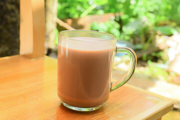 Glass of chocolate milk with natural scenery 
