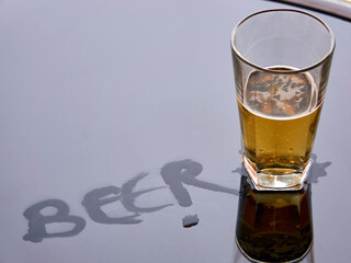 beer in a glass on a table with beer written on it