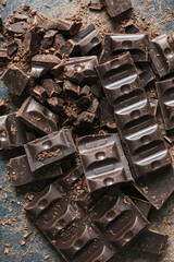 Broken bar of dark chocolate close-up on a dark background.