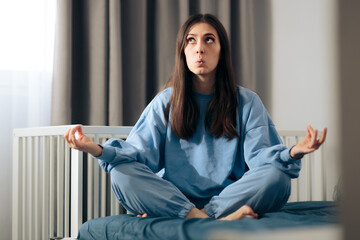 Fototapeta premium Mother in Lotus Yoga Pose Relaxing in Nursery Room