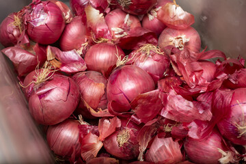 A view looking into a bin full of red onions.