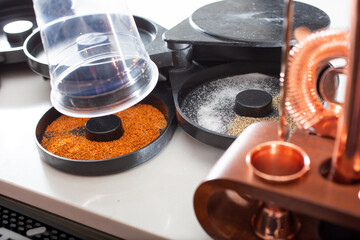 A view of a plastic cup being prepared to receive a garnish of chili lime salt, in a restaurant or bar setting.