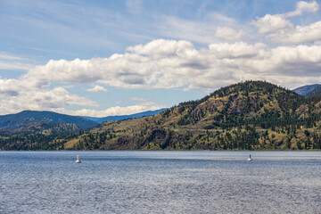Fototapeta na wymiar calm morning lake in British Columbia Canada blue sky with white clouds.