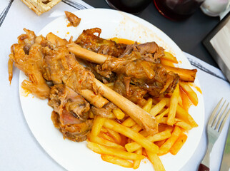 Tasty mutton meat in sauce stewed in oven served with crispy fried potatoes. Spanish cuisine