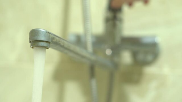 Leaking faucet in the bathroom. Water drops dripping from the mixer in the shower
