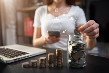 Business woman holding coins putting in glass with using  smartphone to calculate concept saving...