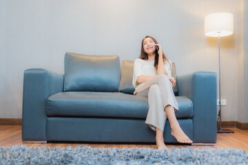 Obraz premium Portrait beautiful young asian woman use smart mobile phone on sofa