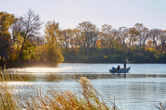 Fishing on a beautiful lake early morning with leaves turning colors on a pretty fall day