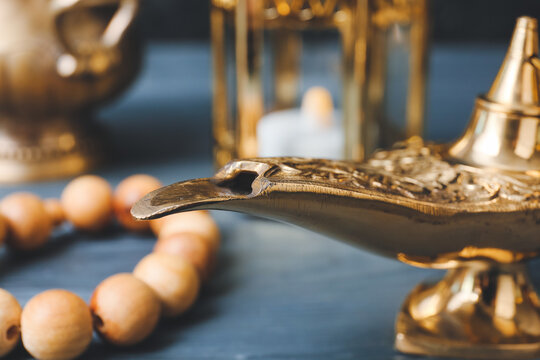 Aladdin lamp of wishes and tasbih on table, closeup