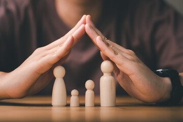 Protecting Hands Over wooden Family, Family Protection And Care Concept, family home, foster care,...
